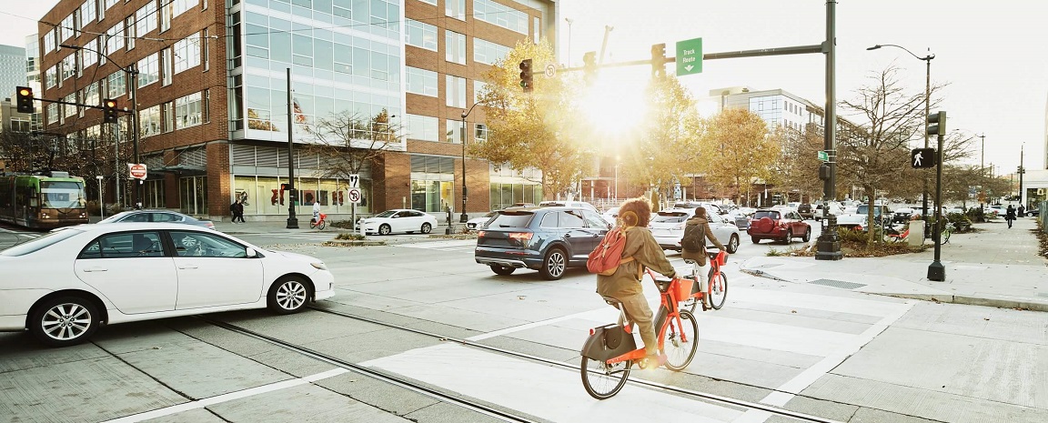 banner mobilidade urbana: ciclistas e carros em uma rua