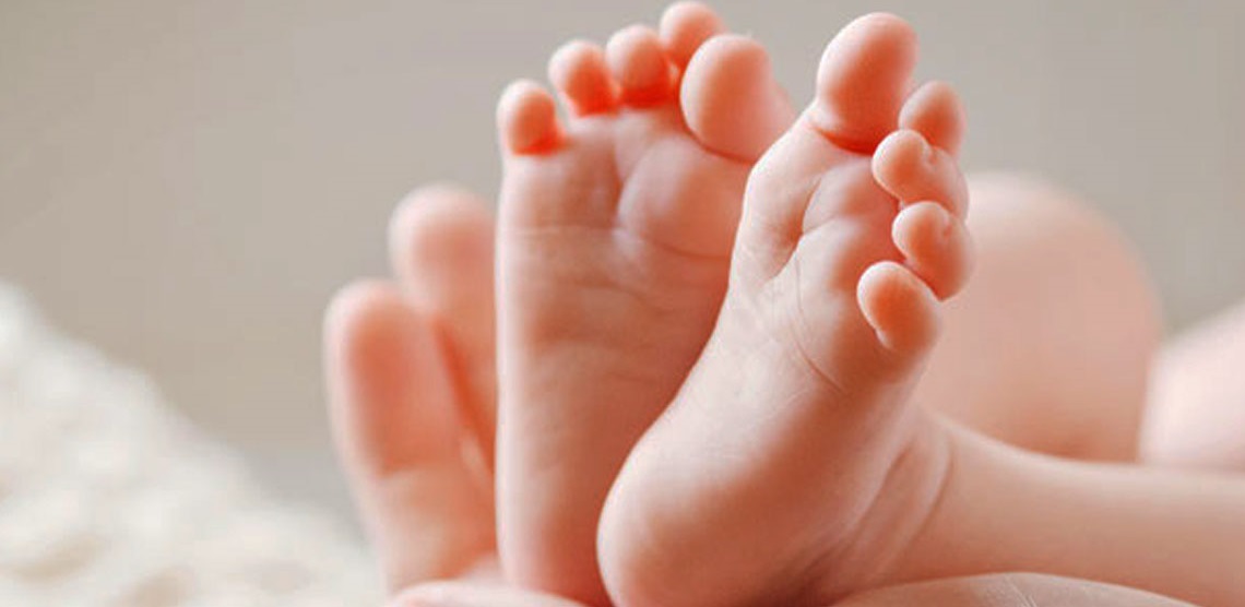 neonatologista segurando os pés de um bebê